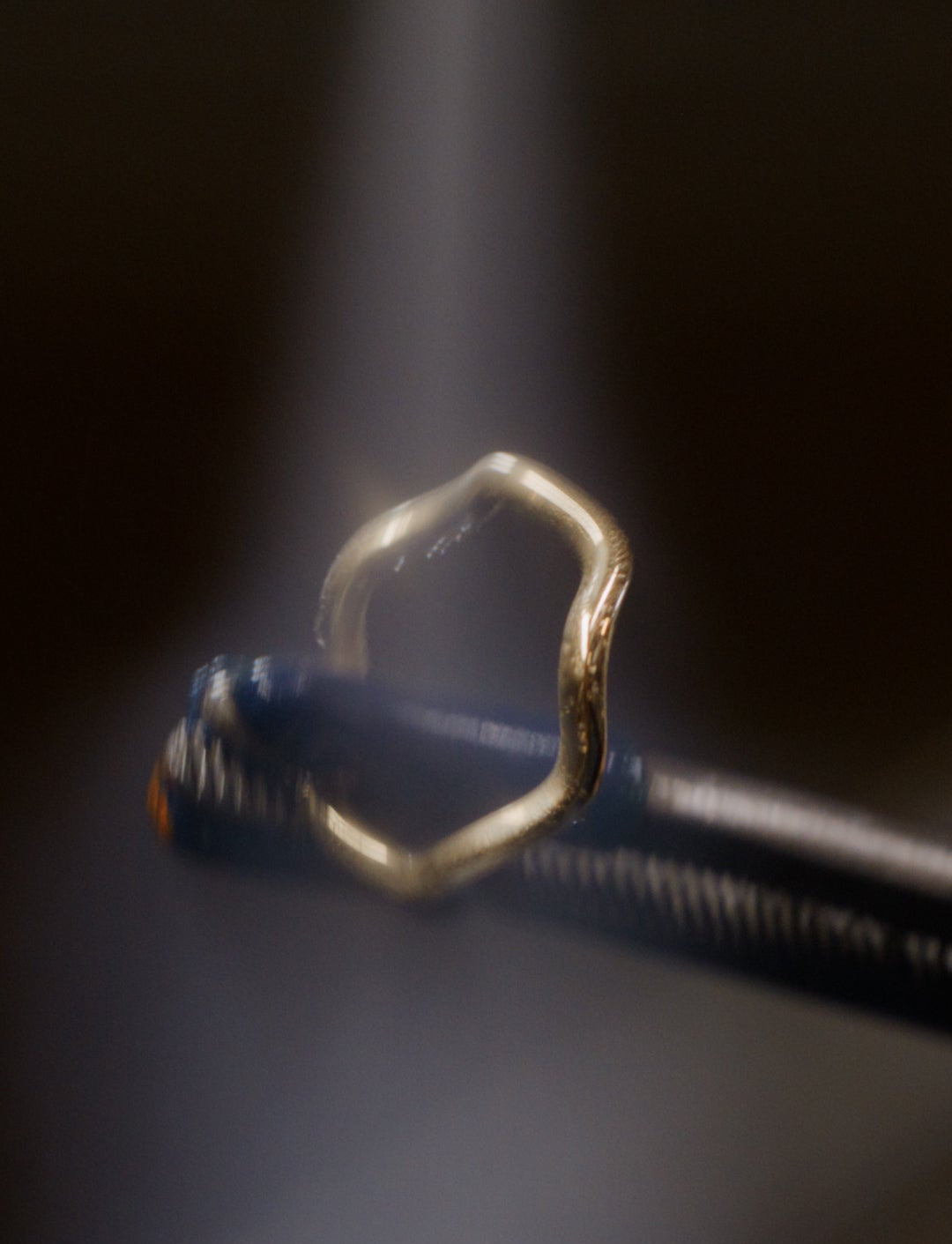 Metal being held and molded under a light.