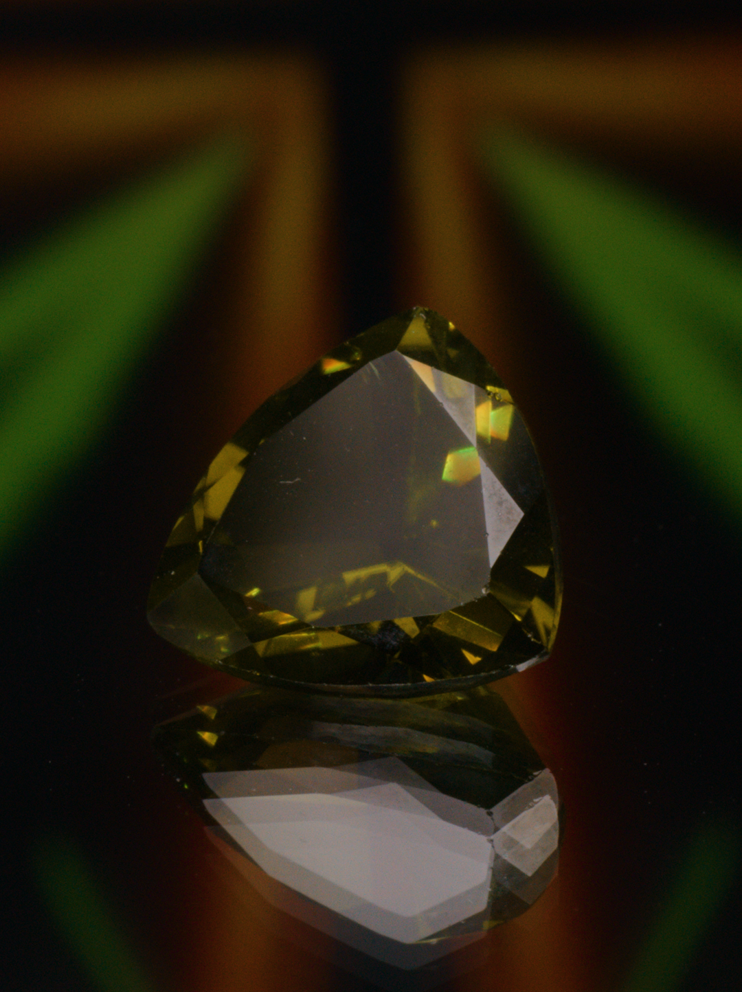 Green gemstone with green lights on a desk.
