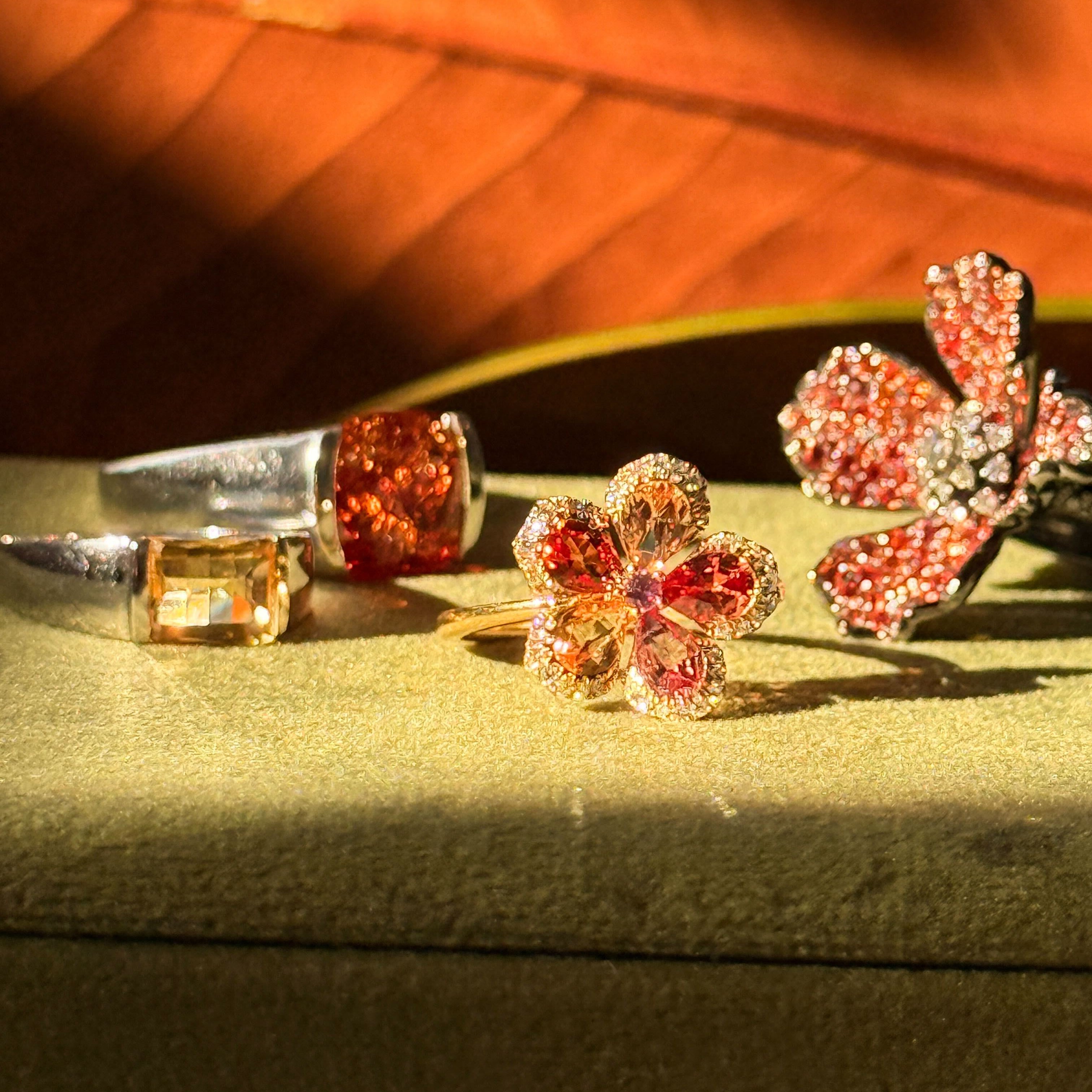 Flower-shaped jewelry pieces on a textured surface with a blurred background. The life of a showgirl collection by vinca