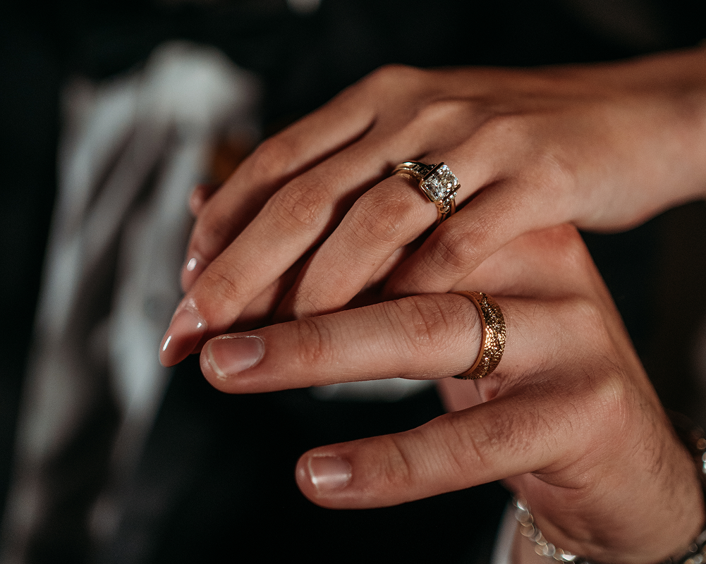 Stacked gold and platinum wedding bands on neutral surface