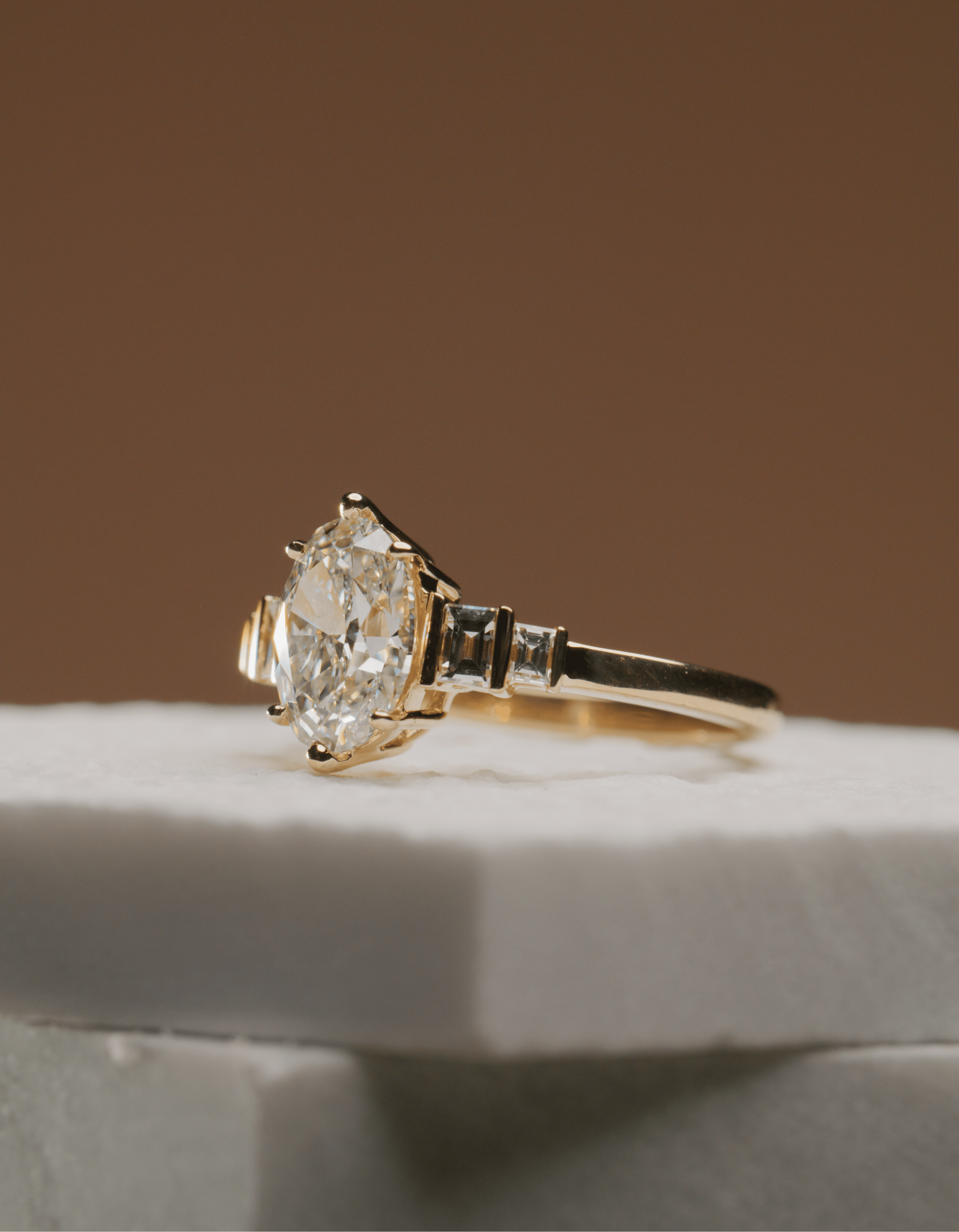 Handcrafted engagement ring laid on marble surface